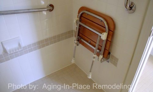 Tile roll-in, wheelchair accessible shower with teak fold up shower seat and grab bars for added safety