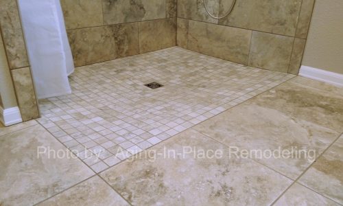 Custom Tile barrier free, roll-in shower with hand held shower head allows for wheelchair accessibility, grab bars for added safety for other bathers