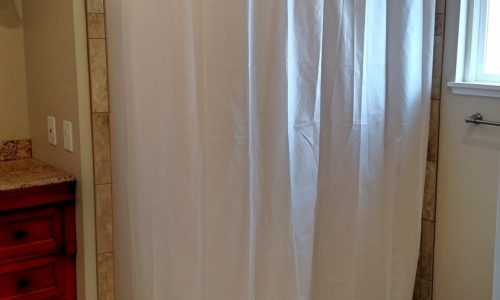 Custom Tile barrier free, roll-in shower with hand held shower head allows for wheelchair accessibility, grab bars for added safety for other bathers