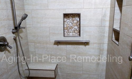 tile barrier free shower with built in shower seat for wheelchair accessibility, includes hand held shower head for easier use