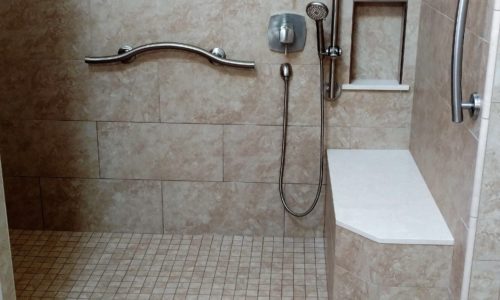 Custom tile shower remodel with built in bench, custom grab bars, hand held shower head, wheelchair accessible, roll-in shower