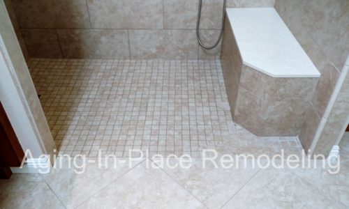 Custom tile shower remodel with built in bench, custom grab bars, hand held shower head, wheelchair accessible, roll-in shower