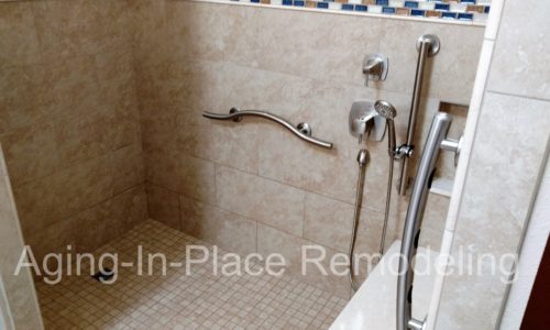 Custom tile shower remodel with built in bench, custom grab bars, hand held shower head, wheelchair accessible, roll-in shower