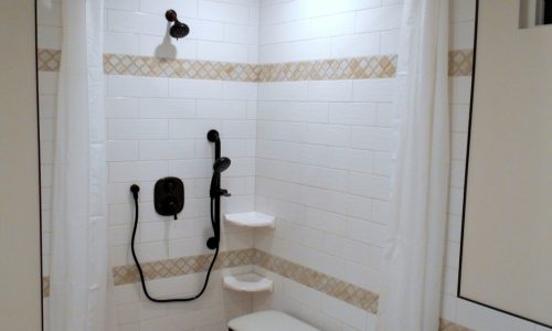 Accessible Renovations wheelchair accessible bathroom remodel with tile roll-in shower, grab bars and fold up shower seat