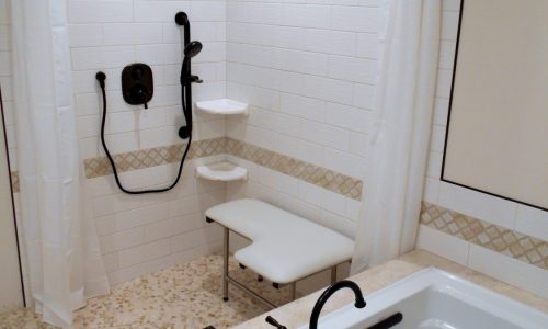 Accessible Renovations wheelchair accessible bathroom remodel with tile roll-in shower, grab bars and fold up shower seat