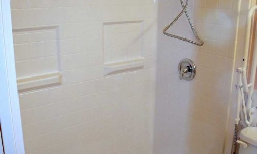 Bathroom remodel for accessibility includes wheelchair accessible roll under sink and Best Bath fiberglass roll in shower