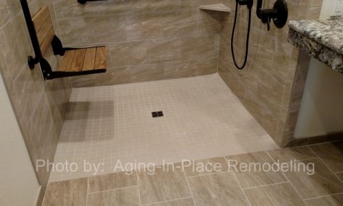 Wheelchair accessible bathroom remodel with tile roll-in shower, roll under sink, fold-up shower seat and grab bars