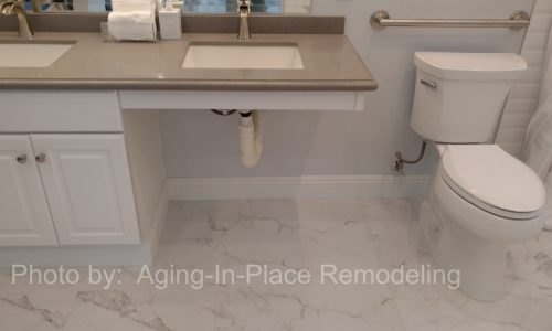 A wheelchair accessible bathroom remodel with roll-in tile shower, with roll under sink, hand held shower head and built in shower bench