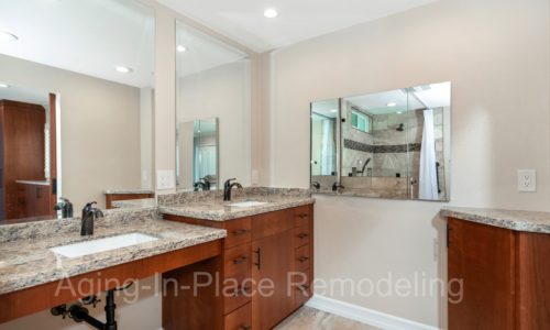 wheelchair accessible bathroom with custom cherry vanity that includes 2 sinks, one standard height, one wheelchair accessible.