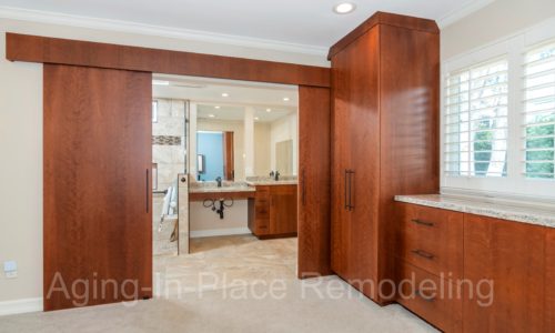 Custom cherry cabinetry, barn doors with one door opening, armoire with automated upper pole