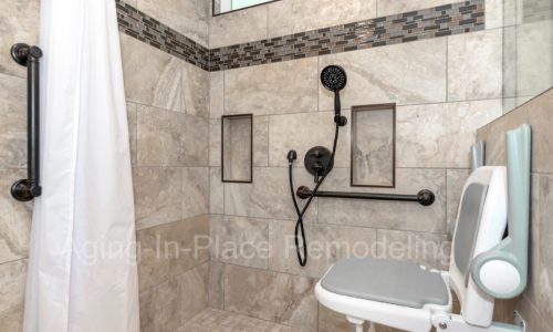 Roll in shower with fold down, wall-mounted shower seat, hand held shower head, grab bars, custom tile