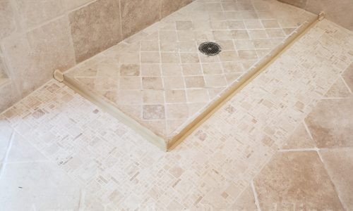 A small shower is remodeled to create a barrier free shower with a water stopper.
