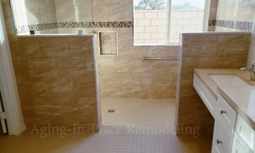 Wheelchair accessible bathroom remodel includes custom tile barrier free shower with built in bench, grab bars, hand held shower head,  The vanity is wheelchair accessible.  