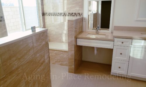 Wheelchair accessible bathroom remodel includes custom tile barrier free shower with built in bench, grab bars, hand held shower head, The vanity is wheelchair accessible.