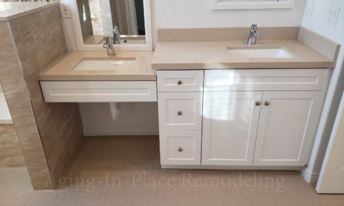 Wheelchair accessible bathroom remodel includes custom tile barrier free shower with built in bench, grab bars, hand held shower head, The vanity is wheelchair accessible.