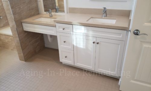 Wheelchair accessible bathroom remodel includes custom tile barrier free shower with built in bench, grab bars, hand held shower head,  The vanity is wheelchair accessible.  