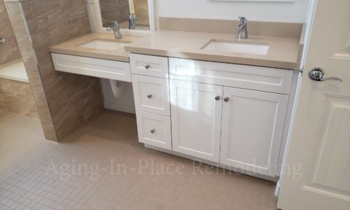 Wheelchair accessible bathroom remodel includes custom tile barrier free shower with built in bench, grab bars, hand held shower head, The vanity is wheelchair accessible.